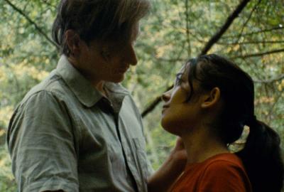 Gordon and Juliette look lovingly at each other in the woods