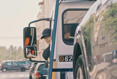 Berta looks back from the driver's seat of her work truck