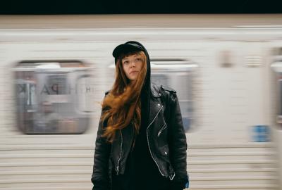 Sid stands in front of a passing subway 