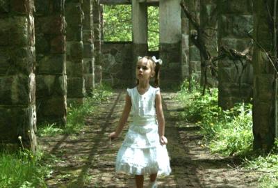 The Captured Bird little girl walking among castle grounds