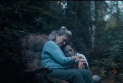 FIONA and MAEVE sit in a chair in the woods