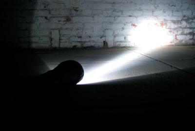 Becoming flashlight shines on brick wall