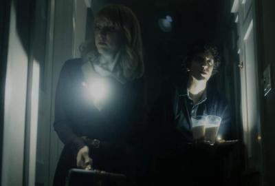 bnb film still couple in a hallway with flashlights