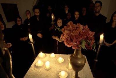 City of Ashes people standing around a table of candles.