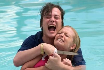 Cruel World a man holds a knife to a woman's throat in the swimming pool