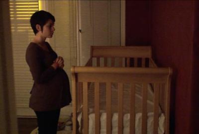 Delivery pregnant woman looks at crib