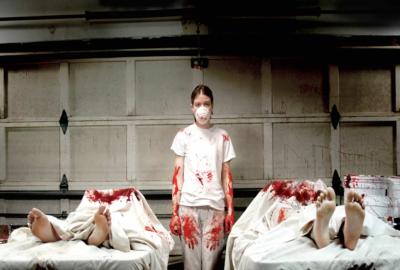 Excision young woman stands between two bloodied bodies