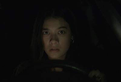 Young woman drives at night