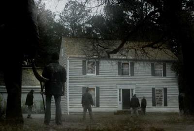 Refuge people standing and looking at a large house