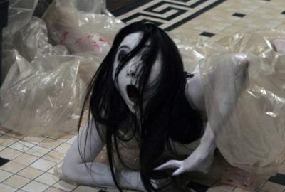 Ju-on: The Grudge female creature with long black hair crawls out of a plastic bag