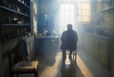 film still old man sitting in chair in the kitchen