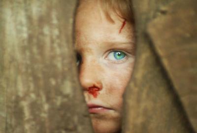 Little Boy Blue film still boy with bloody nose looking through door