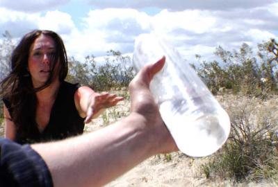 Rations man holds water bottle in front of woman