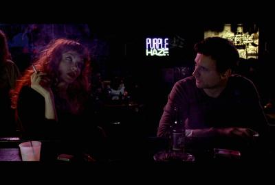 Schism man and woman sit at a bar