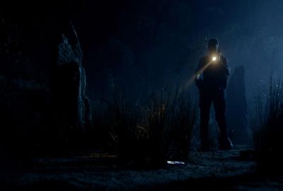 Slaughter At Lonesome Rock film still man with a flashlight in the dark