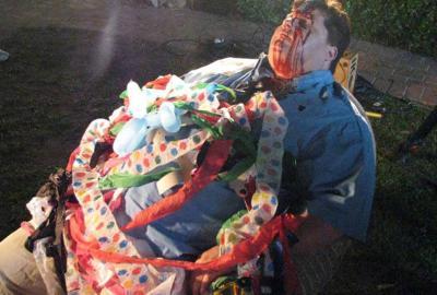 Some Guy Who Kills People dead fat man sits in a chair with birthday decorations on him