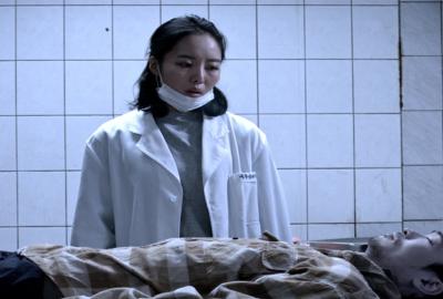 The Ghost film still woman mortician looks over dead body