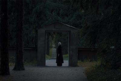 Woodland Cemetery film still person in black standing 