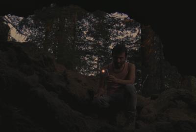 Wanna Go Camping? film still man looking in cave with his flashlight