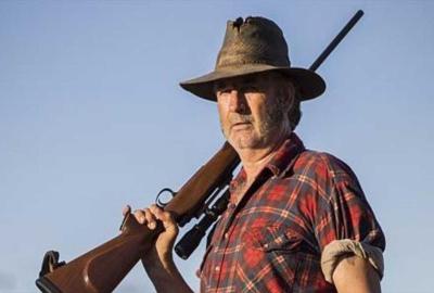 Wolf Creek Mick Taylor holds a rifle